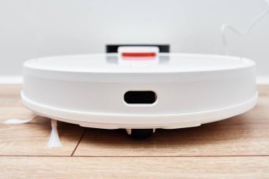 Robot elektrikli süpürge temizlik odasından sonra şarja geri döner. Modern akıllı ev halkı.