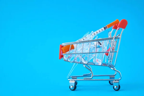 Spritzen Und Ampullen Mit Medikamenten Einem Einkaufswagen Auf Blauem Hintergrund — Stockfoto
