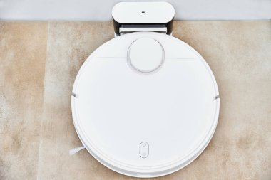 Robot elektrikli süpürge temizlik odasından sonra şarja geri döner. Modern akıllı ev halkı.