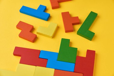 Sarı arka planda farklı tahta bloklar. Mantıksal düşünce ve eğitim kavramı