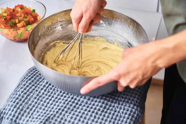 Woman in the kitchen cooking a cake. Hands beat the dough with mixer