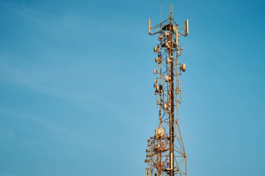 Mavi gökyüzüne karşı antenli iletişim kulesi