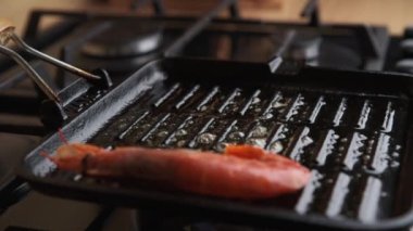 Büyük kral karidesleri ızgaraya koyan kadın.