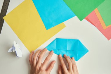 Diy konsepti. Kadın origami paskalya tavşanını renkli kağıttan yapıyor. Origami dersleri