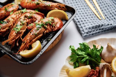 Izgarada limonlu ve baharatlı büyük karidesler.