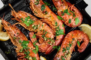 Izgarada limonlu ve baharatlı büyük karidesler.