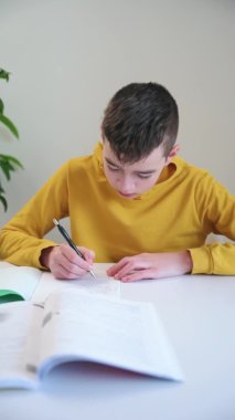 Çocuk ödev yazıyor. Okullu çocuk not defterine not alıyor.