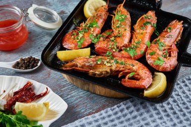 Izgarada limonlu ve baharatlı büyük kraliçe karidesler.