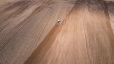 Tarlada tarla süren traktör.