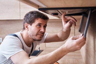 Adam mutfakta kaput onarıyor. Fırın kaputunda yer değiştirme filtresi