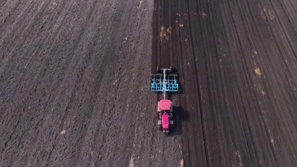 A traktor szántja a talajt művelt mezőgazdasági területen — Stock videók