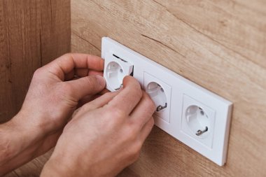 Elektrikçi mutfağa soket takıyor.