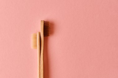 Pembe arka planda yeniden kullanılabilir bambu diş fırçaları. Sıfır atık