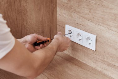 Elektrikçi mutfağa soket takıyor.