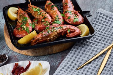 Izgarada limonlu ve baharatlı büyük kraliçe karidesler.