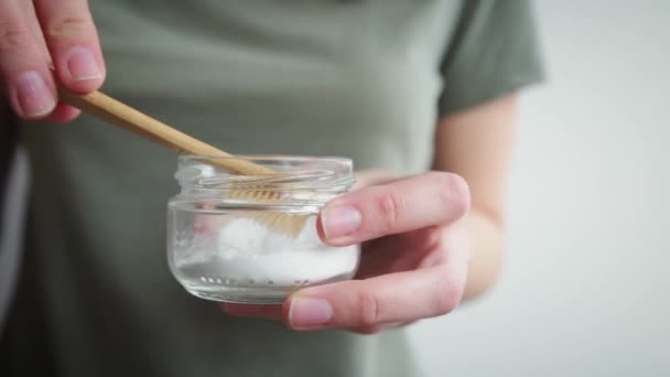 Mulher segura escova de dentes de bambu e pó de refrigerante em suas mãos — Vídeo de Stock