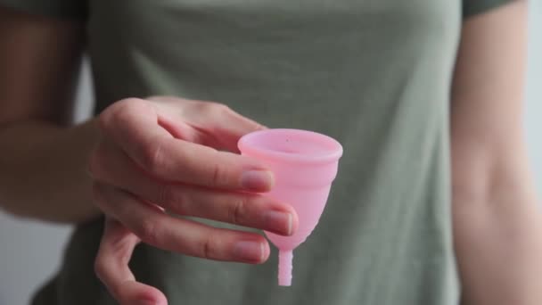 Kobieta trzyma kubek menstruacyjny w rękach — Wideo stockowe