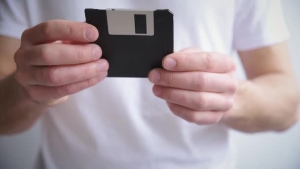 El hombre sostiene el disquete en las manos — Vídeo de stock