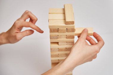 Beyaz arka planda tahta kuleden bir blok öteye gidin. Aile eğlencesi. Tahta oyunu