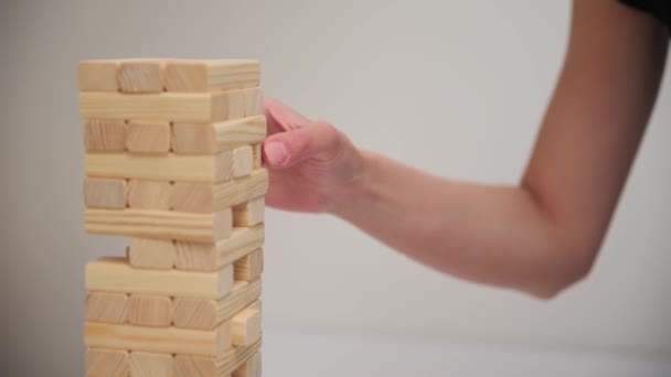 Juego de mesa de juego familiar. Las manos toman el bloque de madera de la torre. — Vídeo de stock