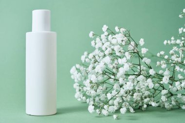 Kozmetik güzellik modeli. Pastel arka planda beyaz şişe