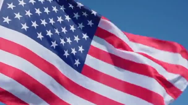 Zwaaien usa vlag in de hand tegen de blauwe lucht — Stockvideo