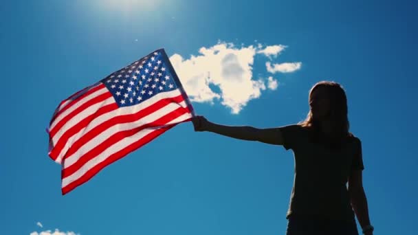 Femme tient Etats-Unis drapeau contre ciel bleu — Video