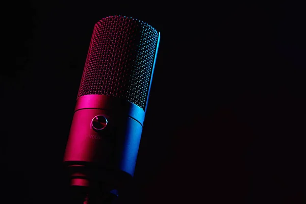 Mikrofon studyjny na ciemnym tle ze światłami neonowymi — Zdjęcie stockowe