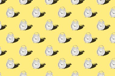 Sarı zemin üzerinde klasik alarm saati olan kusursuz desen