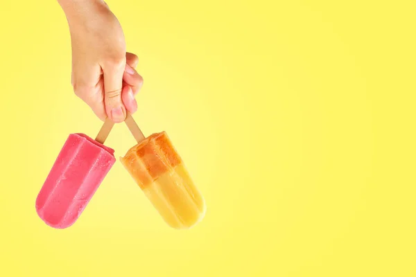 Dos paletas de color en manos de mujer sobre fondo amarillo — Foto de Stock