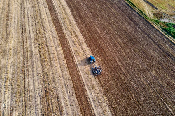 Trator arados chão no campo de fazenda cultivada — Fotografia de Stock