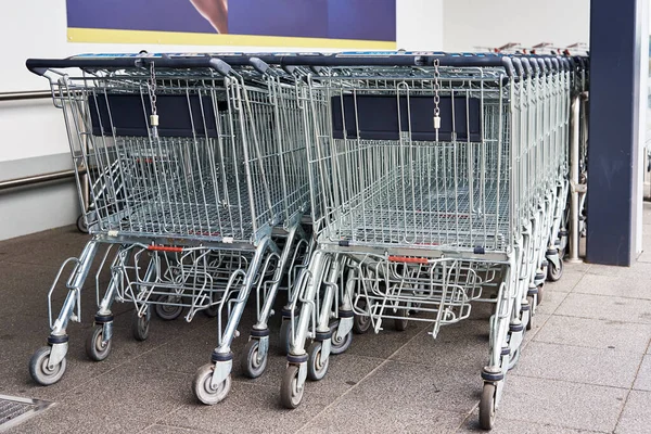 Fila de carrinho de compras vazio perto de uma loja, close-up — Fotografia de Stock