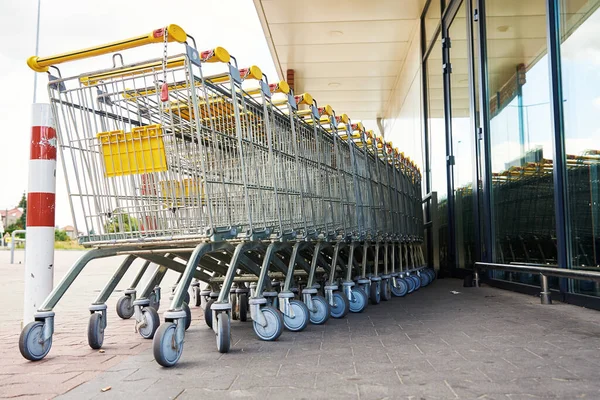 Fila de carrinho de compras vazio perto de uma loja, close-up — Fotografia de Stock