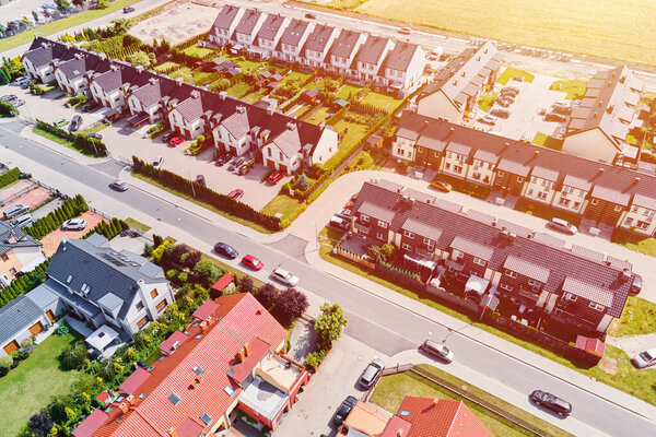 Modern residential district in Europe town, aerial view. Residential neigborhood in sunset, bird eye view. City streets with luxury house buildings and parked car