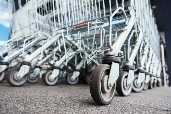 Rij lege winkelwagentjes bij een winkel, close up — Stockfoto