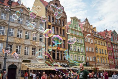 Sokak sanatçısı, çocukları ve turistleri eğlendirmek için şehir sokaklarında büyük baloncuklar çıkarıyor..