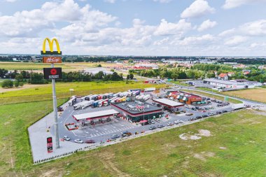 Otoyoldaki McDonalds Restoranı. Park yerinde kamyonlar var.