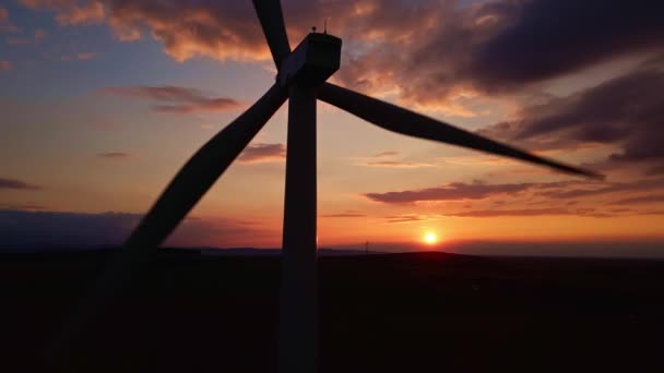 Szélmalom turbina sziluettje a mezőn a naplemente égboltján. Forgó szélgenerátor — Stock videók