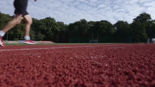 Mann läuft auf Rennstrecke am Stadion — Stockvideo