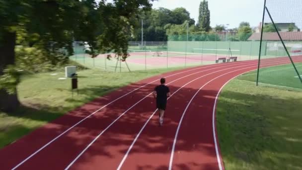 Man running at race track at stadium — Stock Video