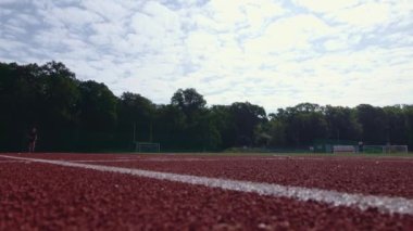 Stadyumda yarış pistinde koşan bir adam