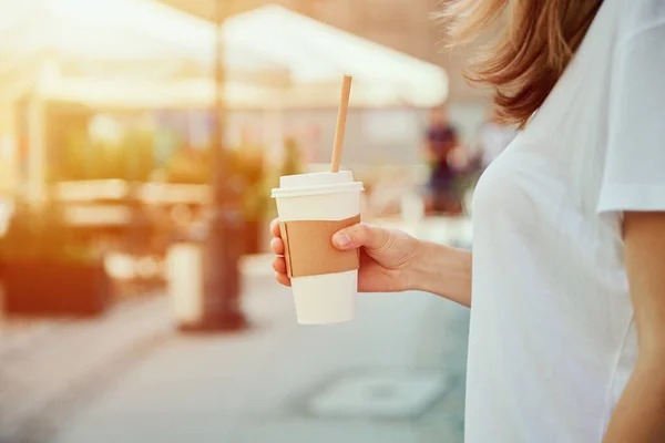 Femme tient tasse de café en papier à la rue de la ville — Photo