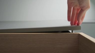 Kadın mutfak dolabının kapısını aç ve içine tabak koy.