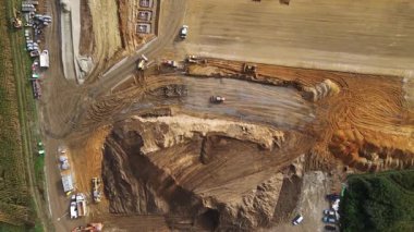 Kazı makineleri ve kamyonlarla inşaat alanının havadan görüntüsü. Toprak, lojistik depo inşa etmeden önce çalışır. Geliştirme, mühendislik ve altyapı kavramı