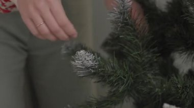 Evdeki tatil süslemesinden önce yapay Noel ağacı dallarını ayarlayan elleri kapatın. Noel hazırlığı ve kış kutlaması kavramı