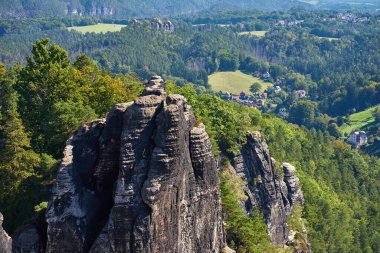 Almanya 'daki Sakson İsviçre Ulusal Parkı' ndaki kumtaşı kayalıkları ve yeşil ormanın panoramik manzarası. Doğal dağ manzarası