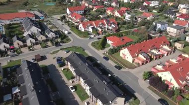 Güneşli bir günde şehir merkezinde evleri, bahçeleri ve park halindeki arabaları olan modern konut manzarası. Sıra sıra kasaba evleri olan modern yerleşim yerleri