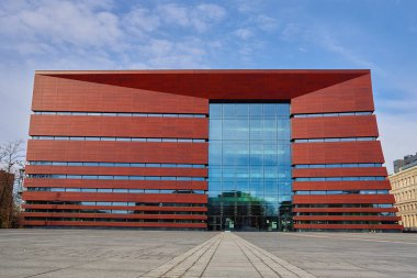 Wroclaw, Polonya 'daki Ulusal Müzik Forumu' nun modern kırmızı ve cam cephesinin ön görüntüsü. Mimarlık, kentsel tasarım ve kültürel yapı kavramı. Wroclaw, Polonya - 16 Şubat 2022