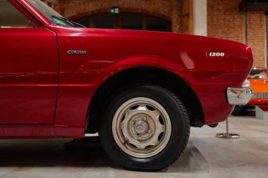 Müzede tekerlek, çamurluk ve rozetli kırmızı Toyota Corolla 1200 'ün sol ön tarafında. Wroclaw, Polonya - 4 Aralık 2022