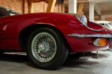 Kırmızı bir Jaguar E-Type 'ın ön sol ön tarafında tel tekerlek, far, tampon ve gösterge var. Wroclaw, Polonya - 4 Aralık 2022